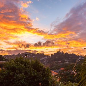 Aerial view of houses and the Bahiravokanda Vihara Buddha Statue on the mountain at sunset in Candy, Sri Lanka